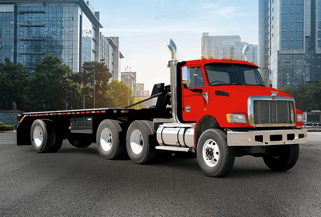 red flatbed tow truck, city in background