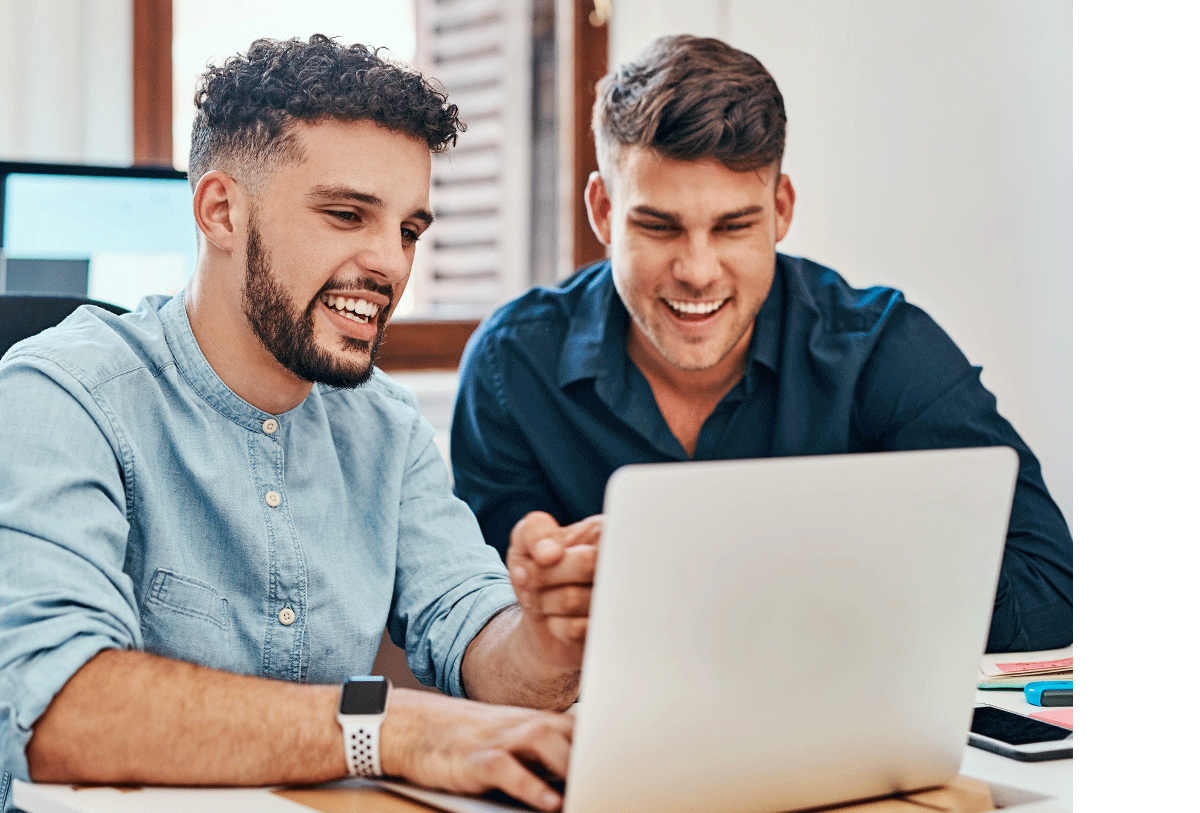 two guys smiling at computer