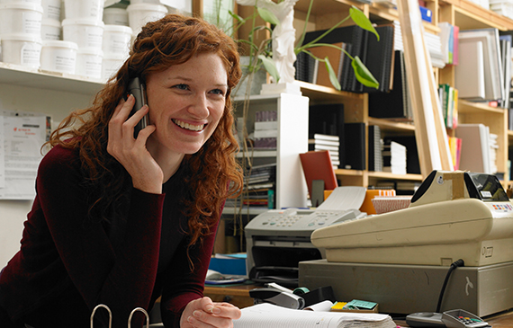 A businesswoman answers a customer call for her Etsy shop. A businesswoman answers a customer call for her Etsy shop.