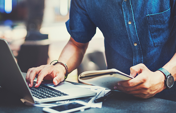 An entrepreneur checks the customer testimonials page on his laptop.