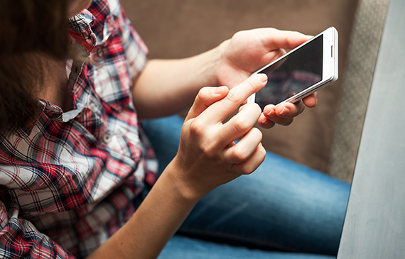 Entrepreneur checks her Facebook business page on her cellphone.