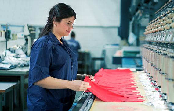 Business owner checks her embroidery machine she got with equipment financing. Business owner checks her embroidery machine she got with equipment financing.