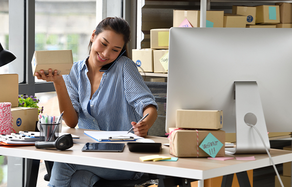 Start-up business owner in the decorated apparal industry speaks on the phone with a Beacon Funding financing consultant about financing needed equipment.