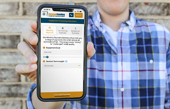 A business owner calculates their embroidery machine's low monthly payment with Beacon Funding's mobile app. A business owner calculates their embroidery machine's low monthly payment with Beacon Funding's mobile app.