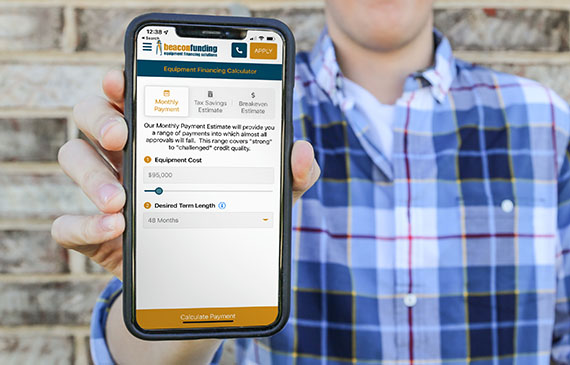 A business owner calculates their embroidery machine's low monthly payment with Beacon Funding's mobile app.