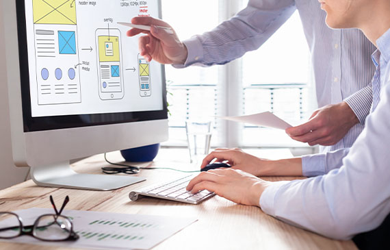 A team of website developers looks at design templates for building a website for different mobile phone screen sizes. A team of website developers looks at design templates for building a website for different mobile phone screen sizes.