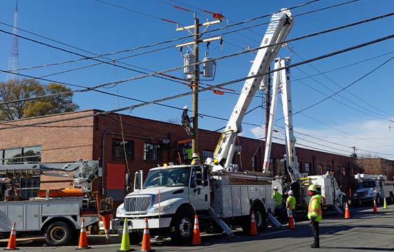 A crew repairs telephone lines using their boom truck.