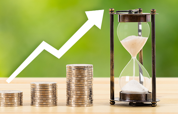 Three stacks of coins in ascending order sit next to an hourglass.