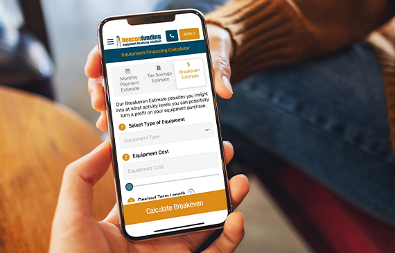 A business owner uses Beacon Funding's breakeven estimate app on their mobile phone.