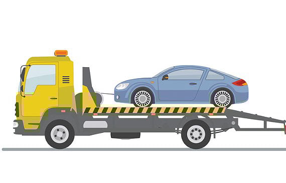 A yellow flatnose flatbed truck tows a blue tesla electric vehicle. A yellow flatnose flatbed truck tows a blue tesla electric vehicle.