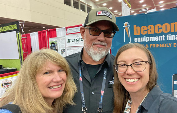 Beacon Funding financing consultants Stephanie Richards and Sandy Young share a photo with TowTruckTech's Chris Young.