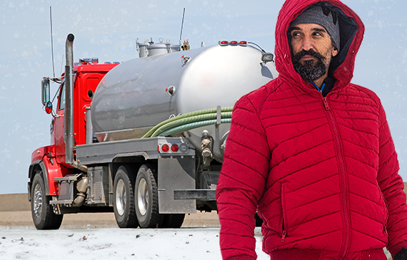 Business owner stands in front of his septic vacuum truck in the middle of winter.