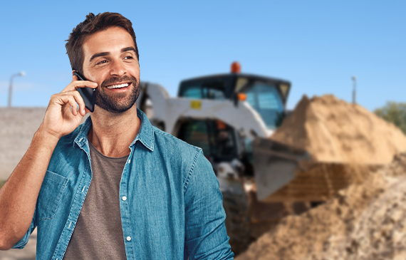 A young male business owner talks on the phone with Beacon Funding's representative about financing a skid steer for their landscaping start-up business. A young male business owner talks on the phone with Beacon Funding's representative about financing a skid steer for their landscaping start-up business.
