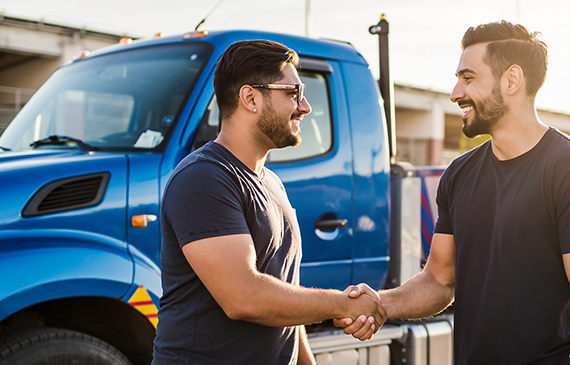 Two business owners shake hands beside a commercial truck, representing Beacon Funding’s equipment financing solutions that help companies grow faster with flexible payments, preserved cash flow, and trusted partnership.