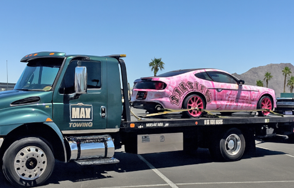 Flatbed tow truck transporting a vehicle, representing how tow operators use Beacon Funding equipment financing to upgrade trucks, expand fleets, and keep cash flow flexible.