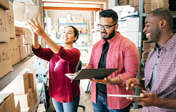 A smiling business owner checks their inventory after receiving financing to purchase needed equipment. A smiling business owner checks their inventory after receiving financing to purchase needed equipment.