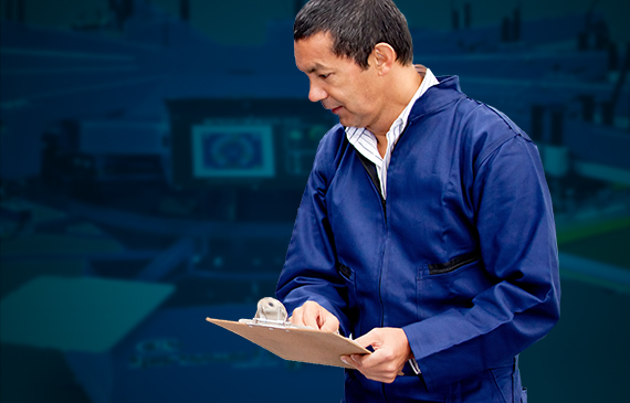 A cleaning professional with a clipboard inspects a screen printing machine.