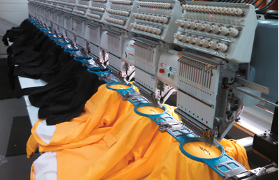 A row of embroidery machines working in unison. A row of embroidery machines working in unison.