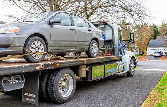 Tow trucks with flatbeds, like this white one, are the preferred vehicle for transporting electric vehicles.
