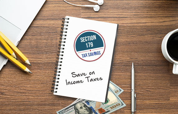 A notepad with the words "Section 179 Tax Savings" lays on a wooden table surrounded by pencils, money, and a cup of coffee.
