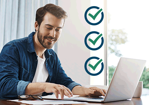 Man looking at computer with check marks appearing.