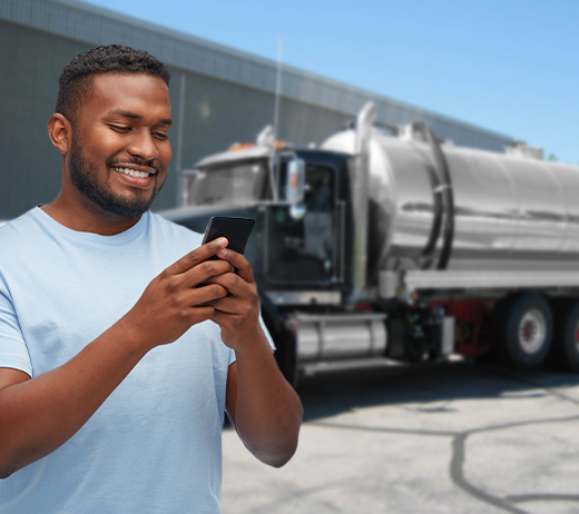Man looking at phone with Septic Pumper Truck in background