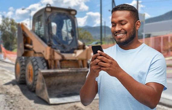A business owner uses his mobile phone to calculate his financing payment for his next skid steer.