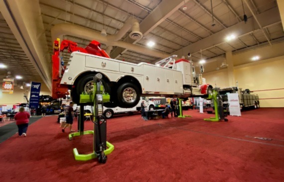 A white heavy wrecker hoisted above the ground at the American Towman ShowPlace 2023. A white heavy wrecker hoisted above the ground at the American Towman ShowPlace 2023.