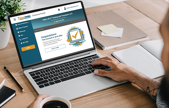 Someone uses Beacon Funding's customer portal to look up their financing account on a laptop.