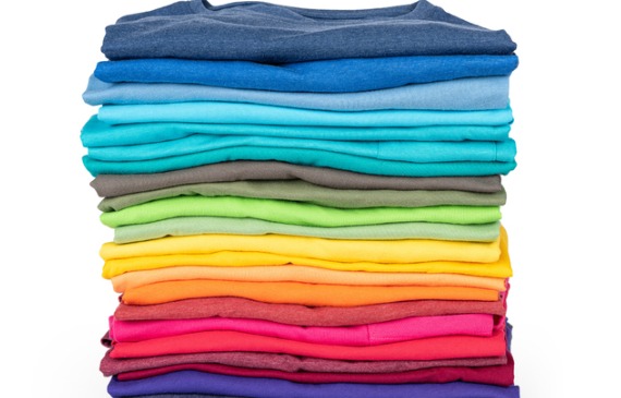 A stacked pile of different colored t-shirts look crisp and fresh for the school season.